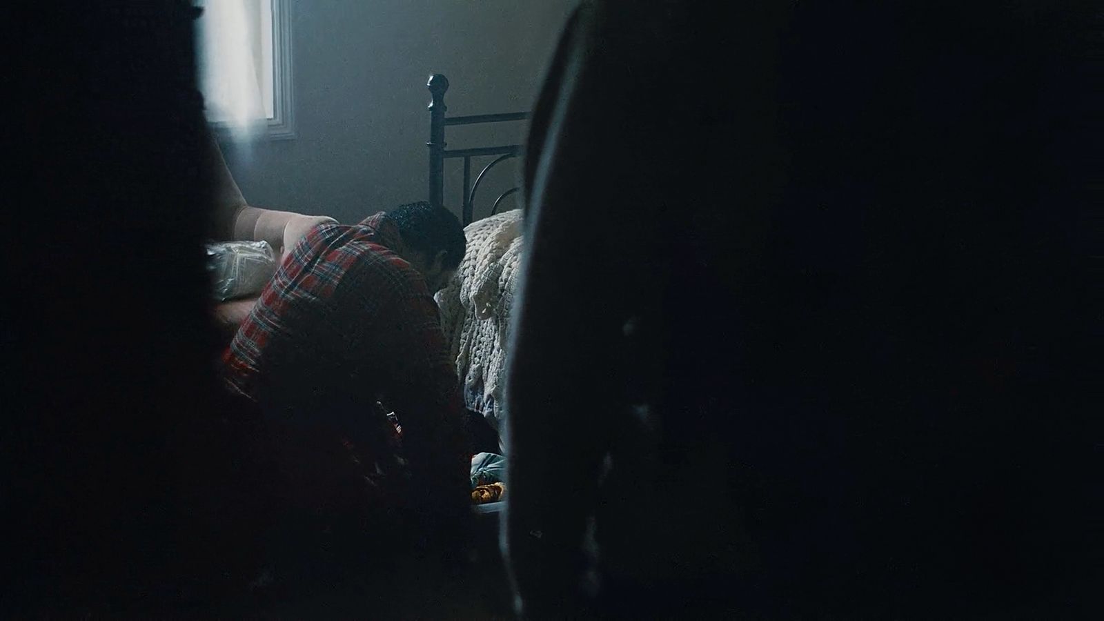 a person laying on a bed in a dark room