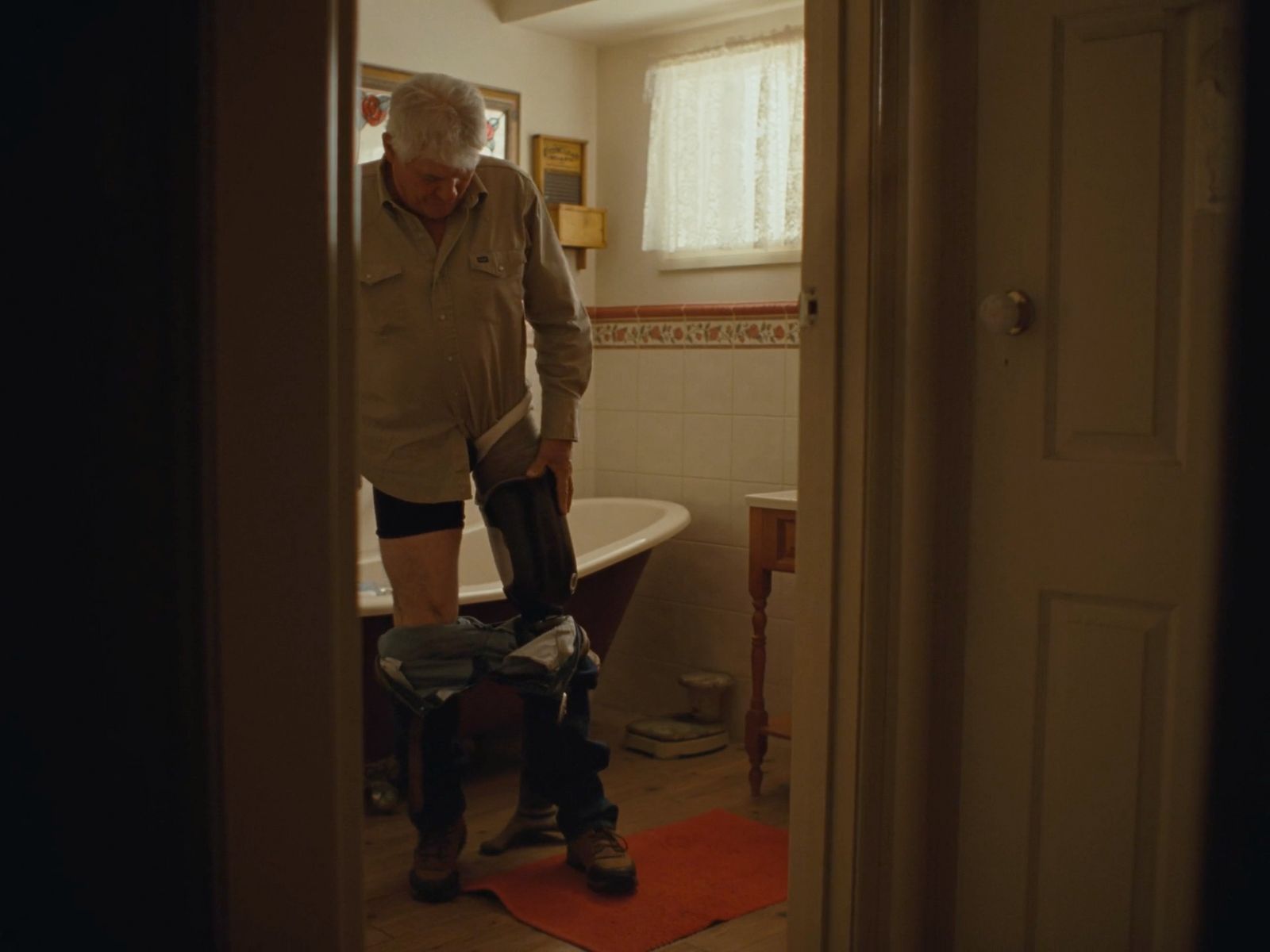 a man standing in a bathroom next to a bath tub