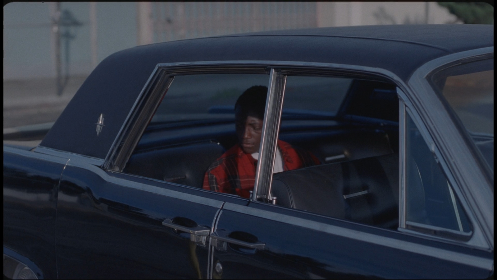 a man sitting in a car looking out the window