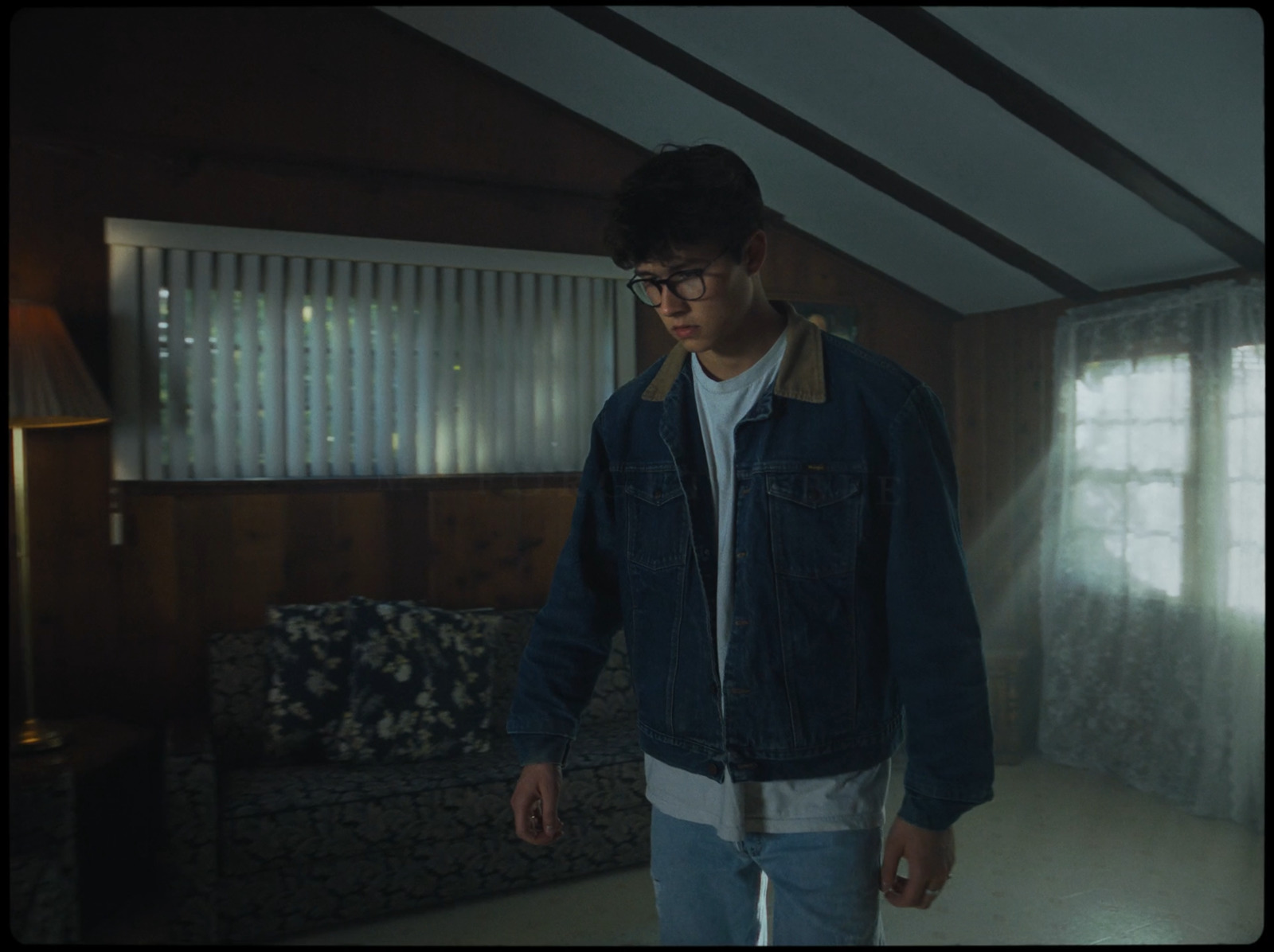 a man standing in a living room next to a couch