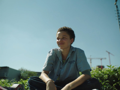 a woman sitting on the ground with a skateboard