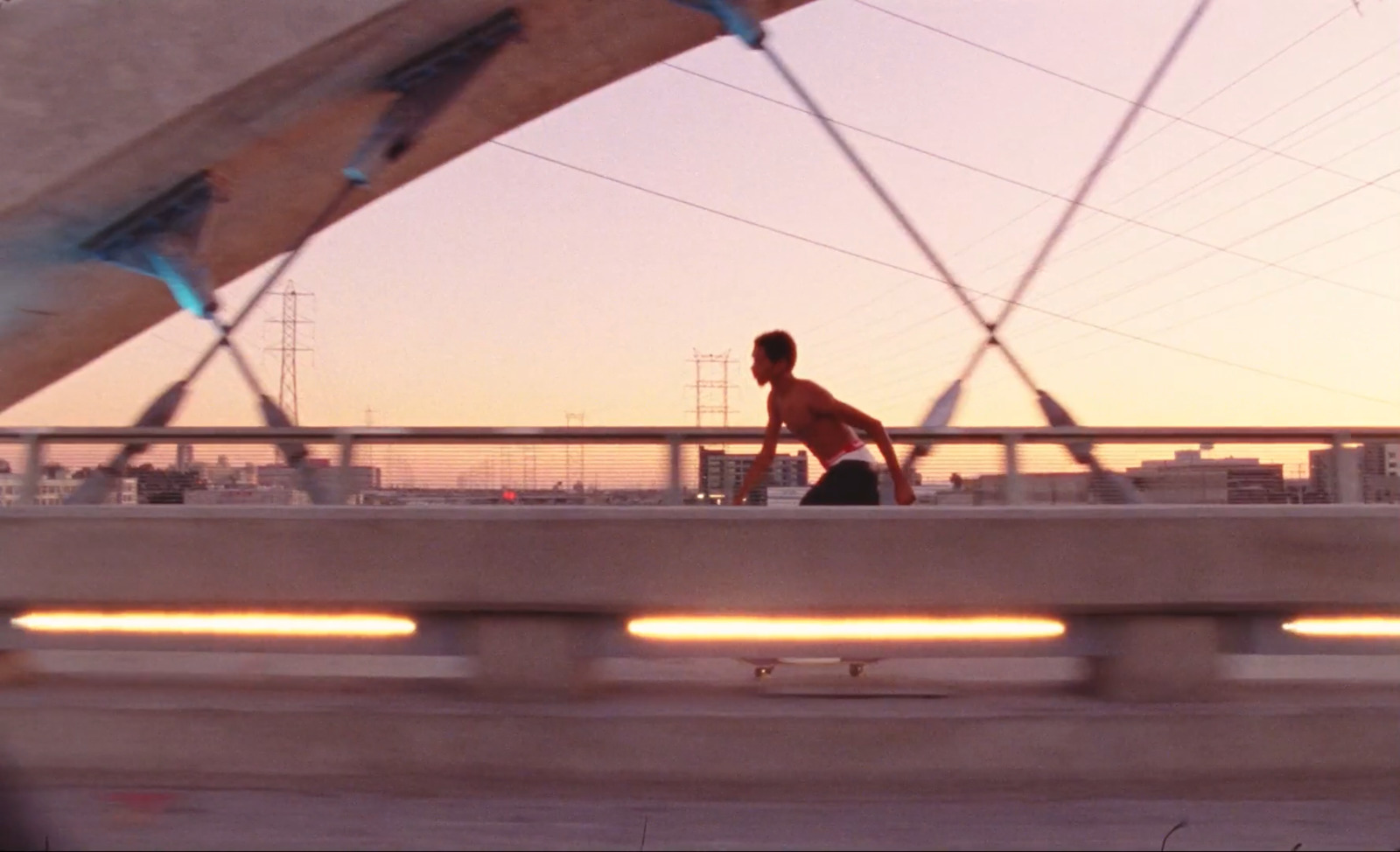 a man riding a skateboard across a bridge