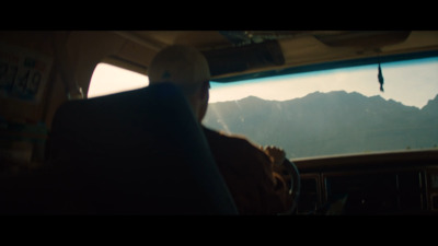 a man sitting in the back of a bus looking out the window