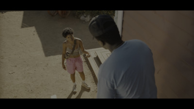 a man standing next to another man on a skateboard