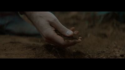 a person holding a handful of dirt in their hand