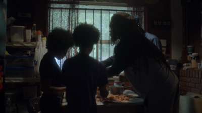 a group of people standing in a kitchen next to a window