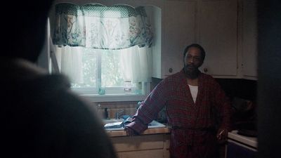 a man standing in a kitchen next to a window