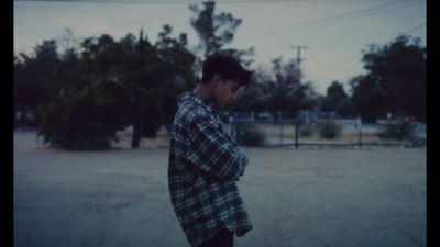 a young man standing in the middle of a field