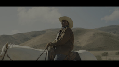 a man in a cowboy hat riding a white horse