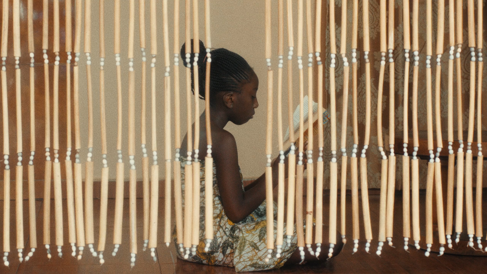 a young girl sitting on the floor reading a book