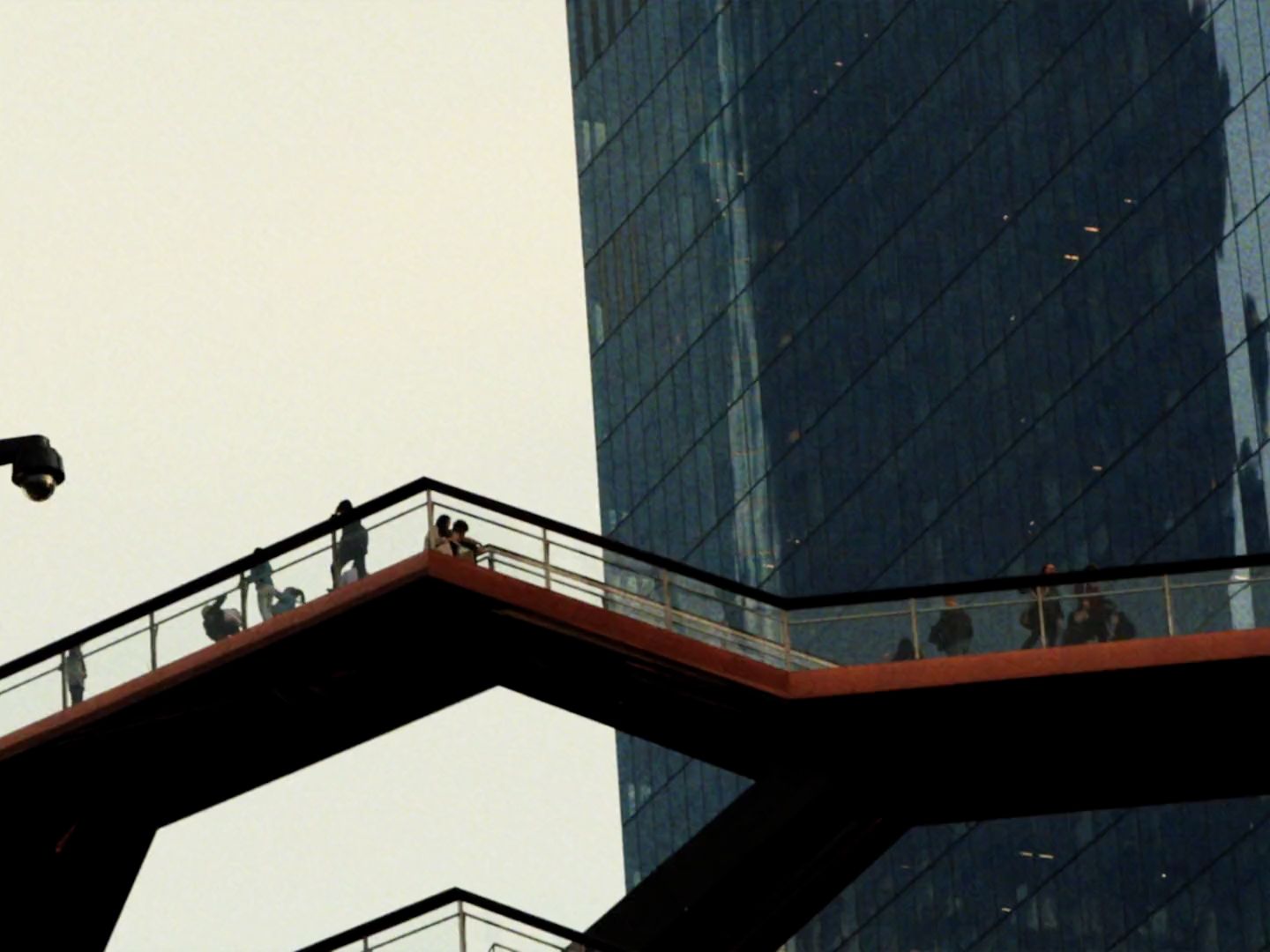 a bird flying over a bridge in front of a tall building