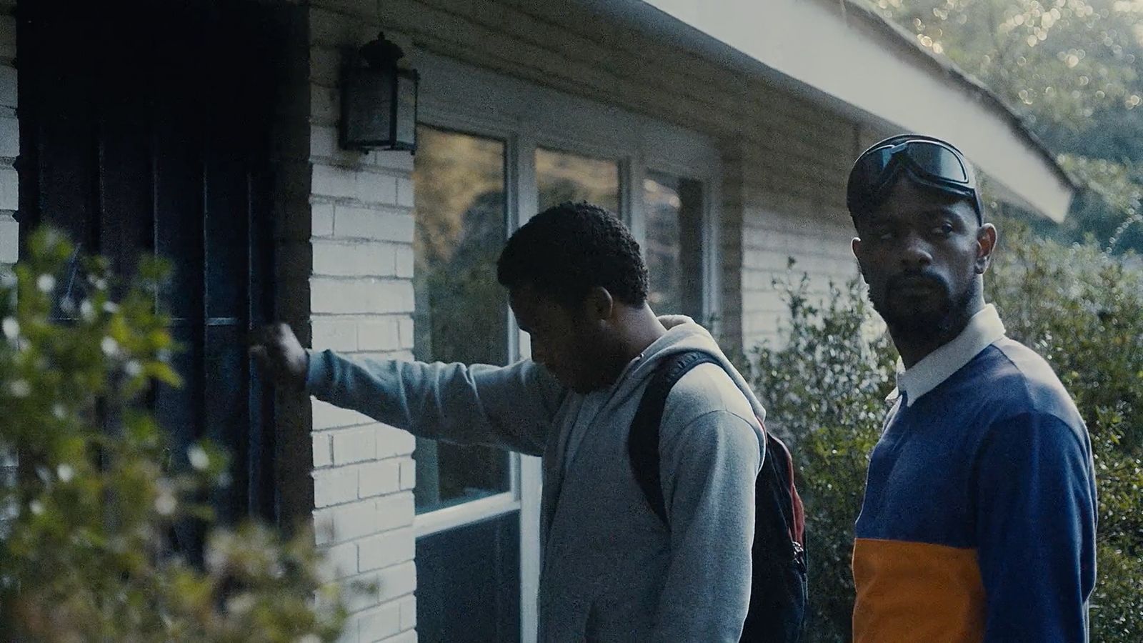 a couple of men standing outside of a house