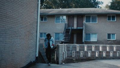 a person standing in front of a brick building