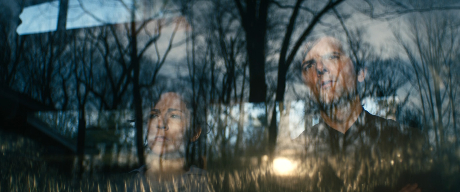 a reflection of a man and a woman in a window