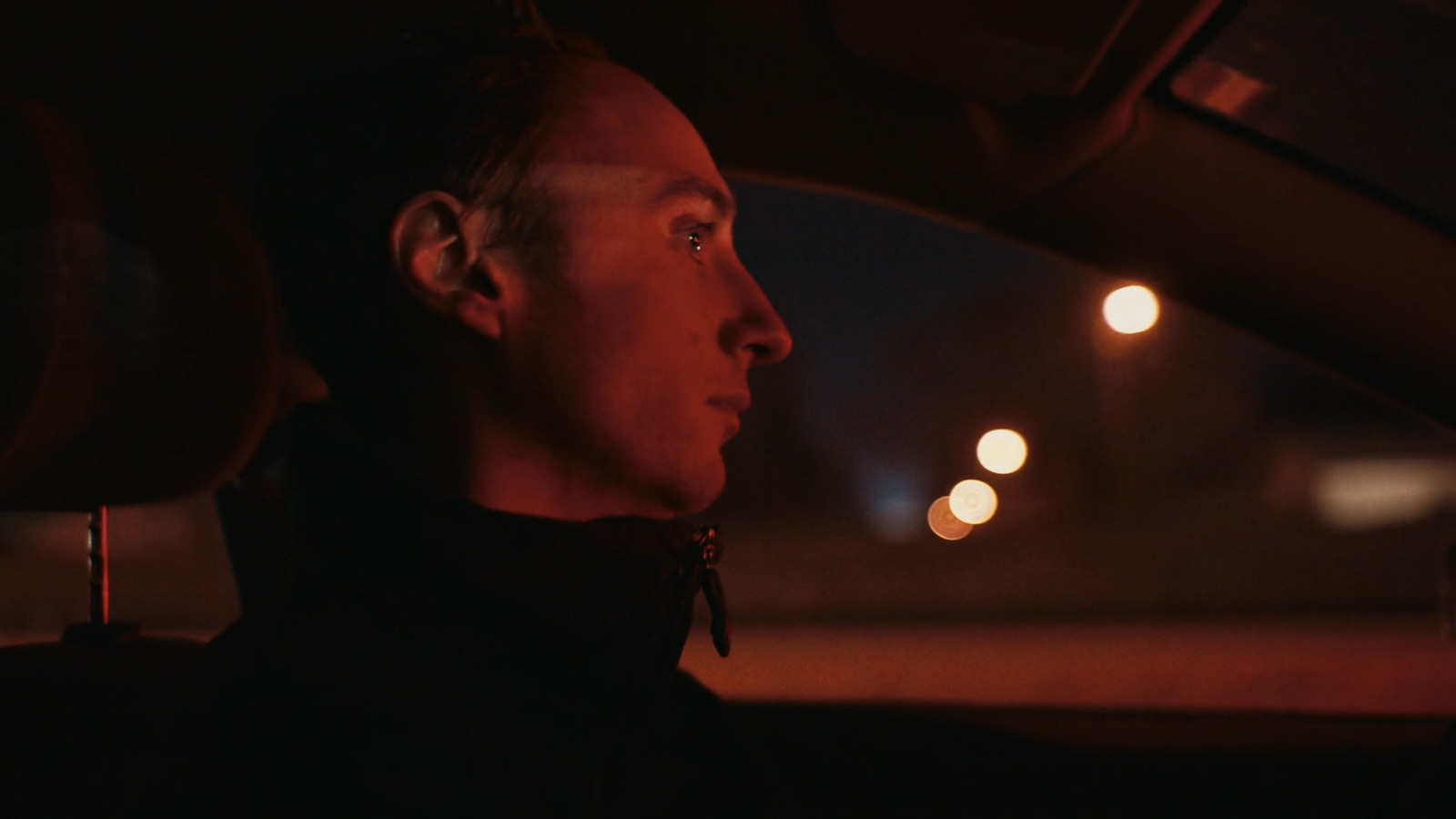 a man sitting in a car at night