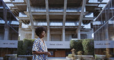 a woman standing in front of a tall building