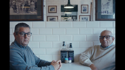 two men sitting at a table in a restaurant