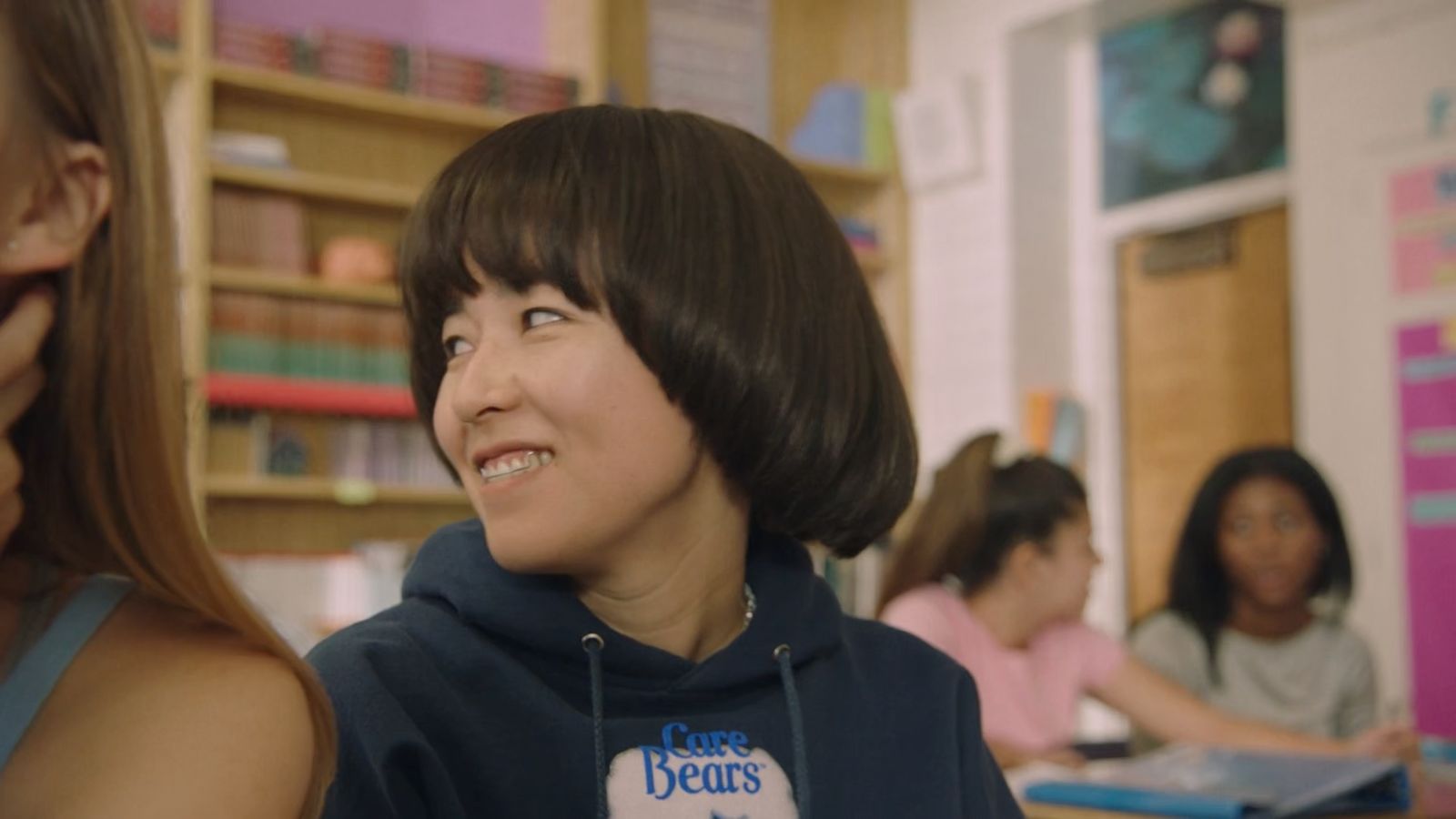 a young girl is smiling in a classroom