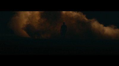 a man standing in the middle of a cloud of smoke