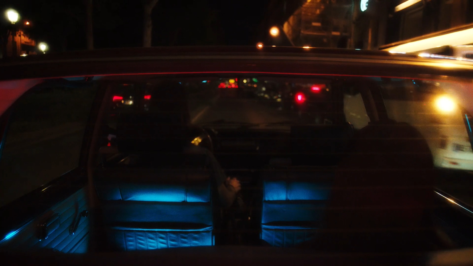 a view of a city street at night from inside a car