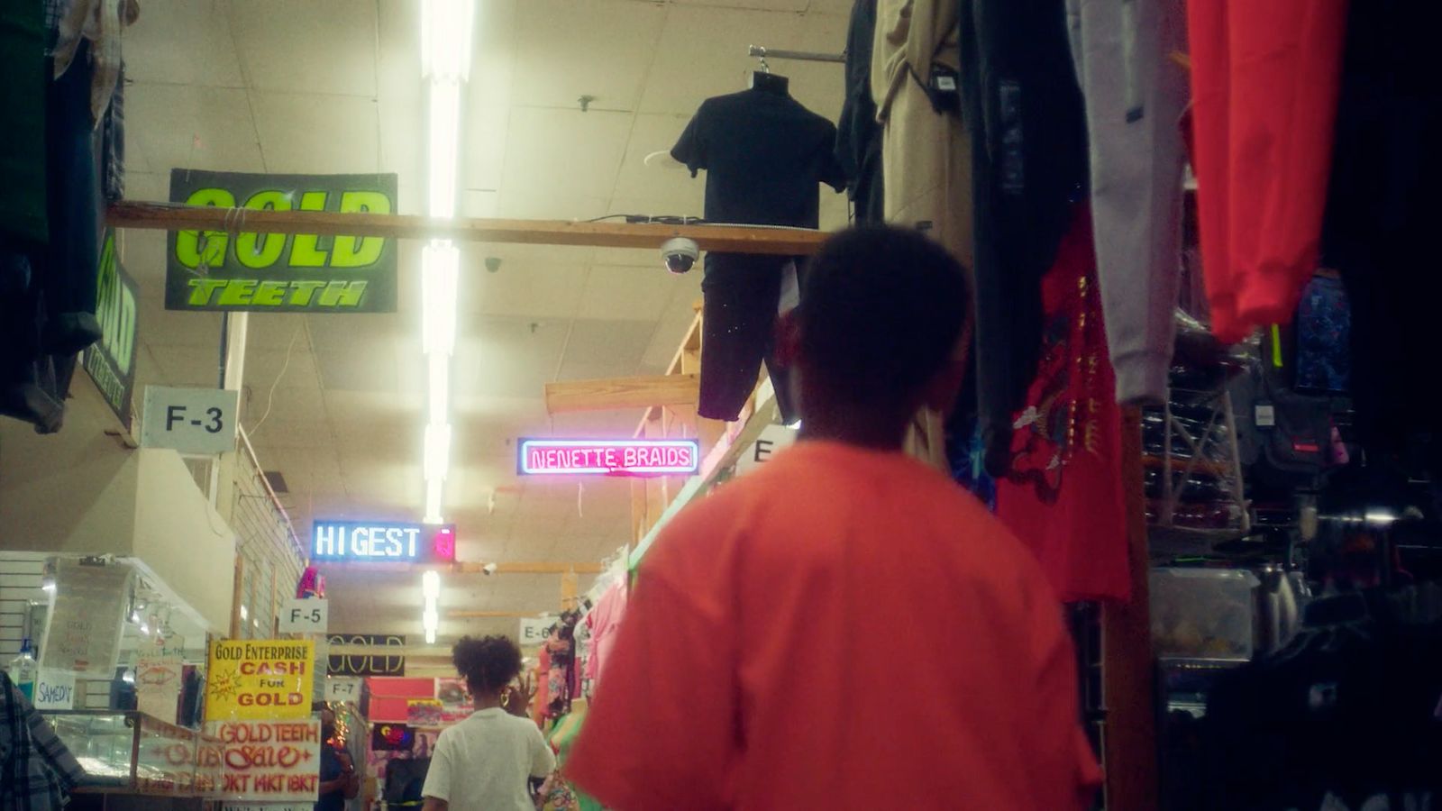 a man walking down a store filled with clothing