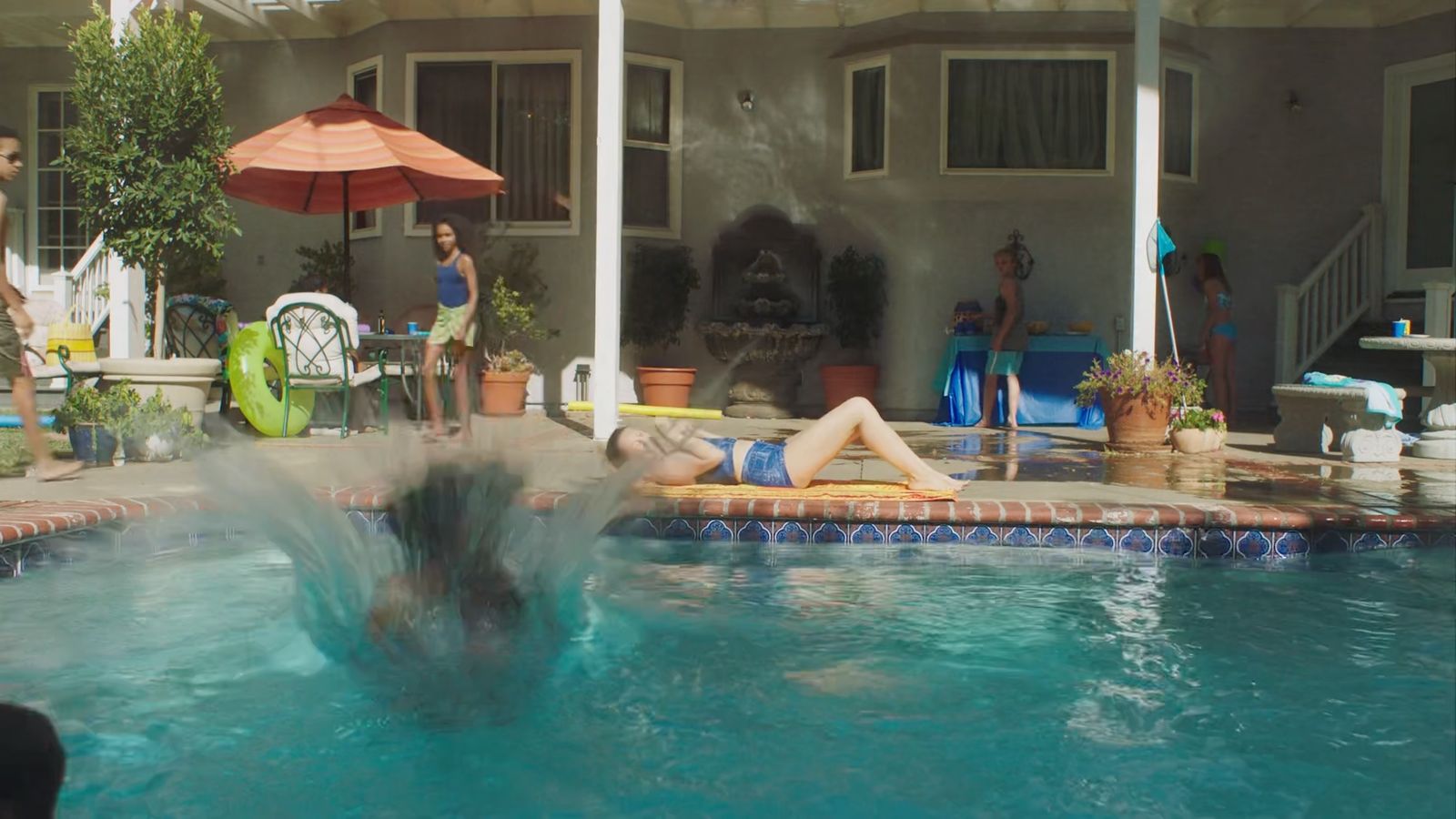 a woman is playing in the pool with her friends