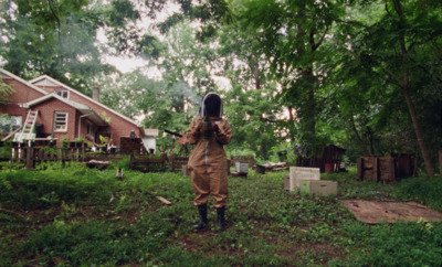 a person in a brown coverall holding a camera