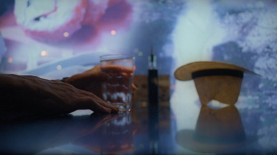 a person sitting at a table with a glass of beer