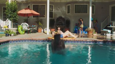 a woman sitting in a pool with a dog