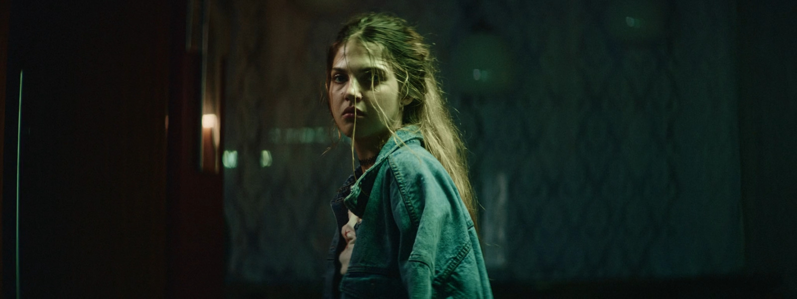 a woman with long hair standing in a dark room