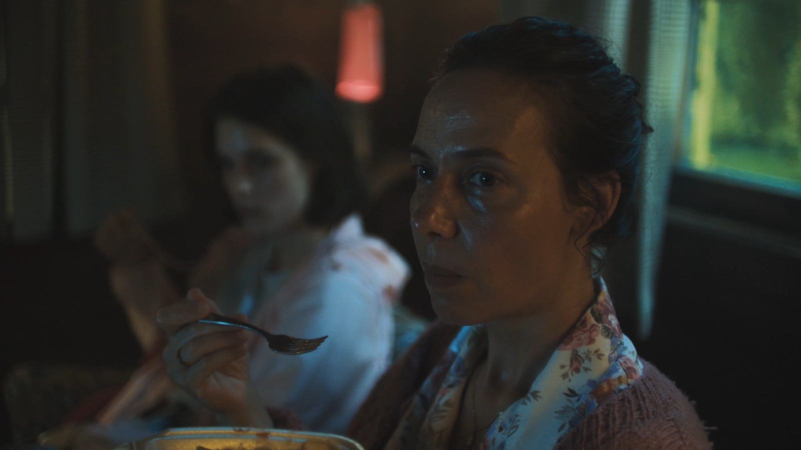 a woman sitting at a table with a bowl of food