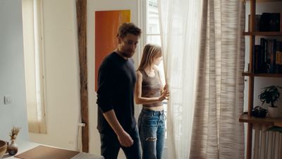 a man and a woman standing in front of a window