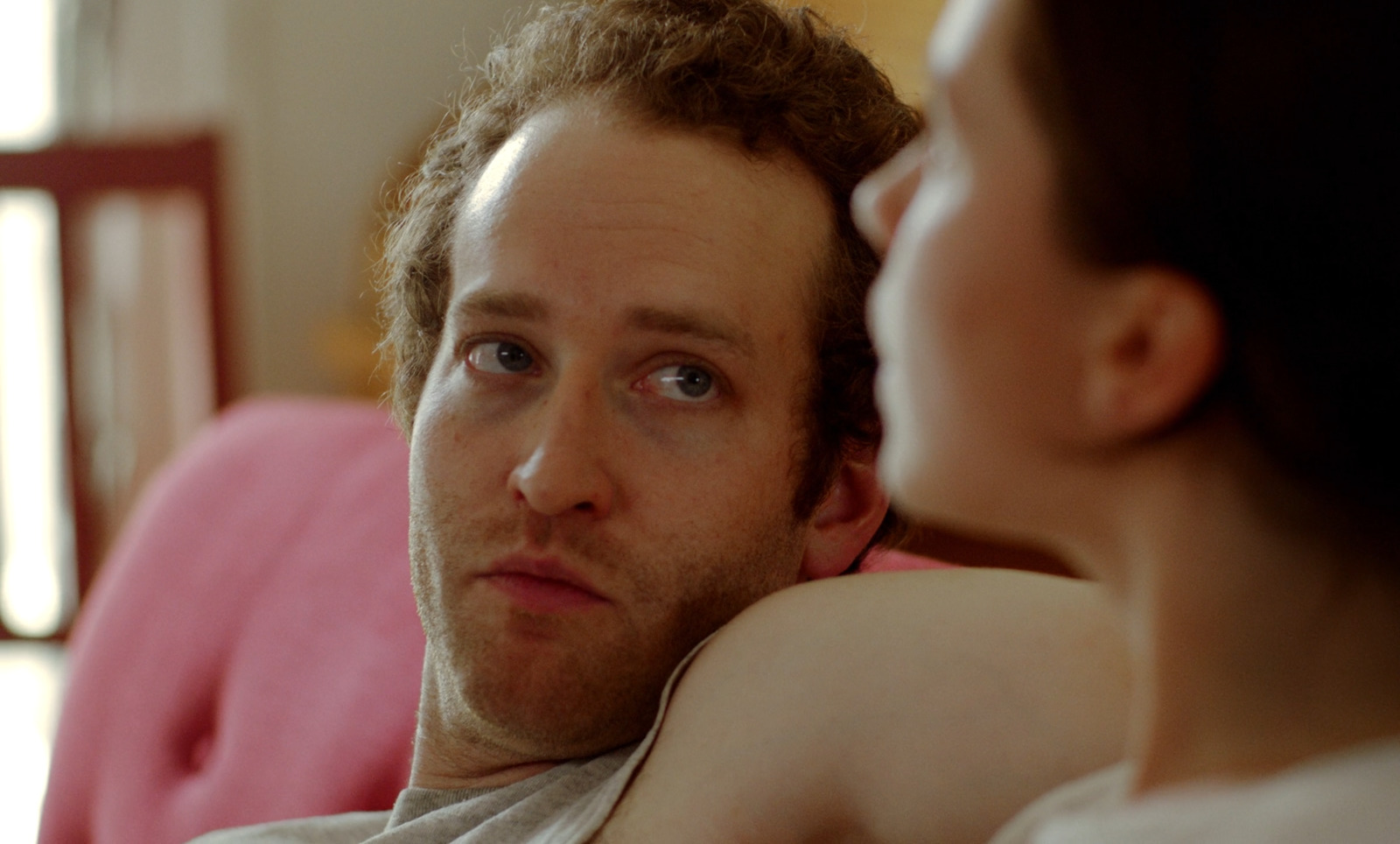 a man and a woman sitting on a couch looking at each other