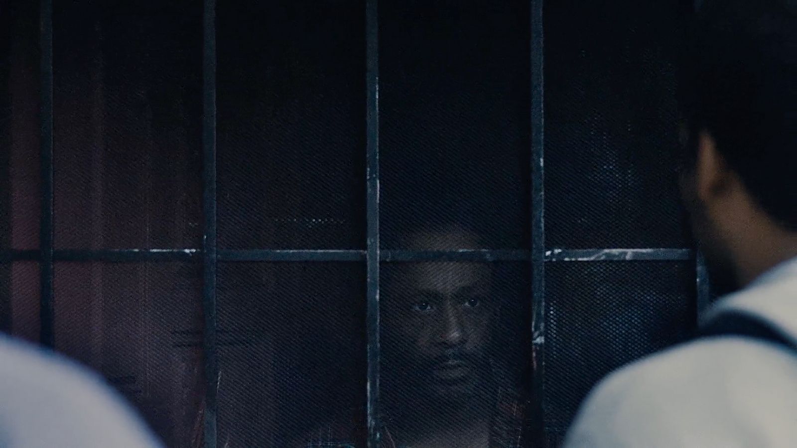 a man standing in front of a jail cell