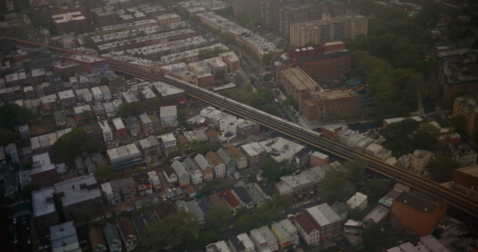 an aerial view of a city with a train on the tracks