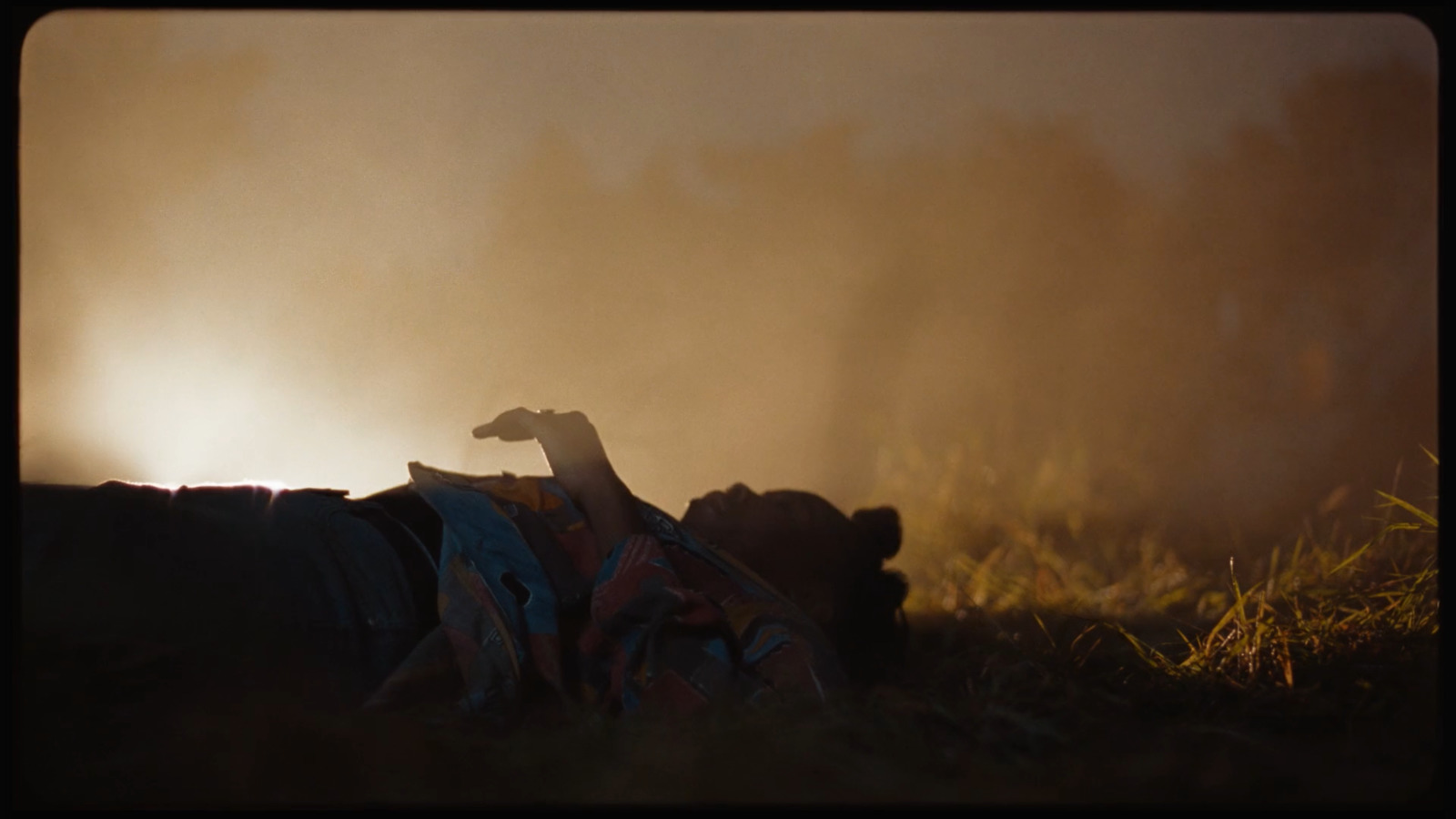 a person laying on the ground in the grass