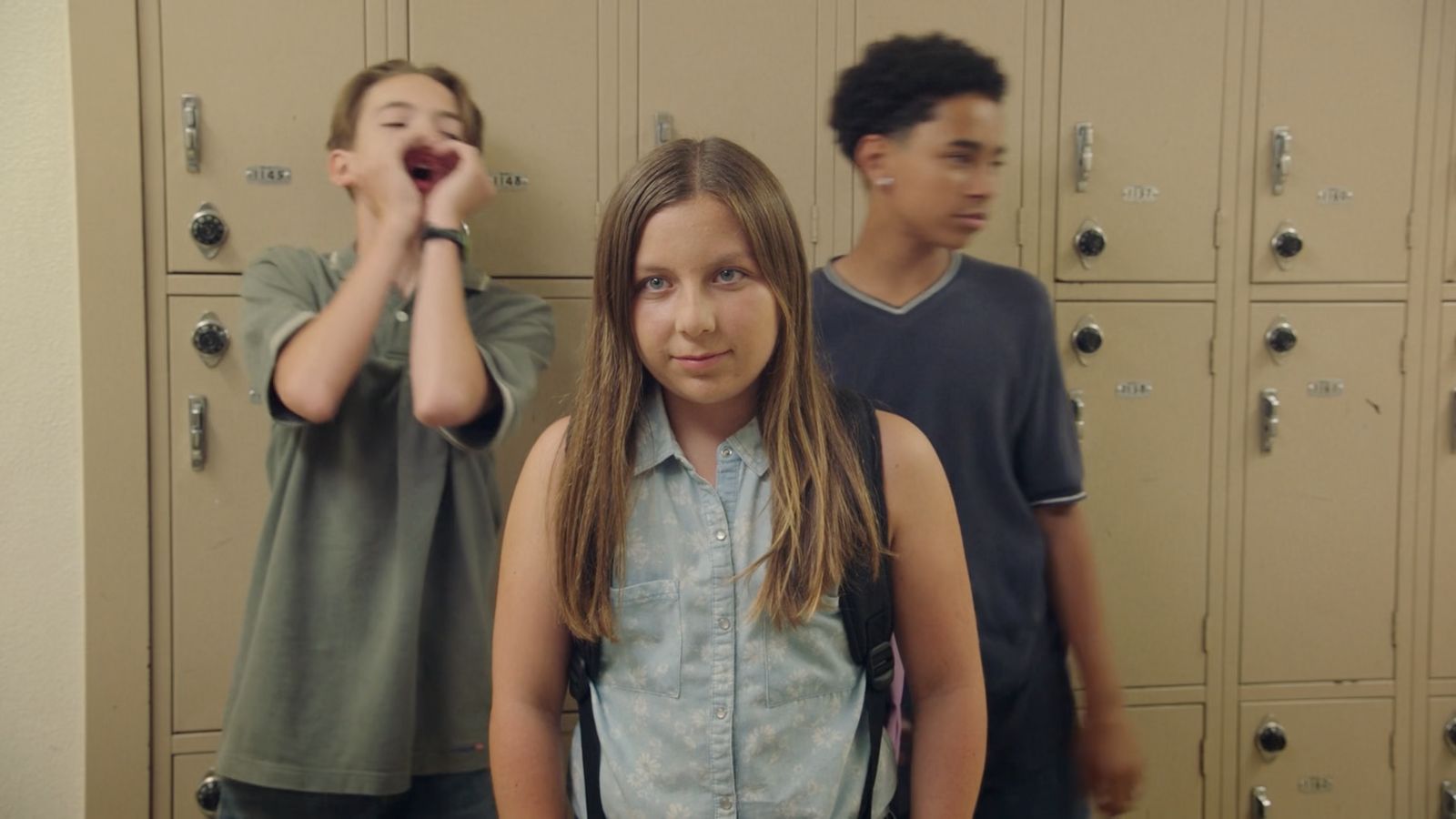 a group of young people standing in front of lockers