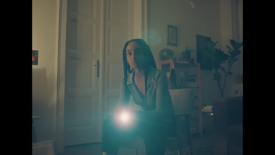 a woman standing in a room holding a flashlight