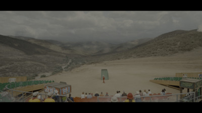 a group of people standing around a dirt field