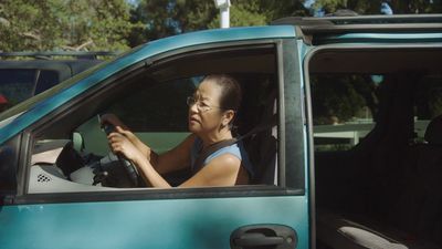 a woman sitting in a blue truck holding a steering wheel