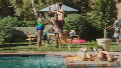 a group of people standing around a swimming pool