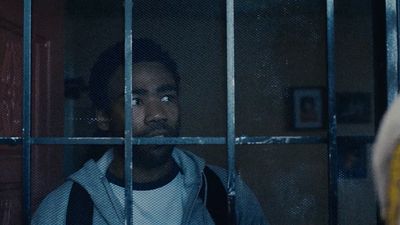 a man standing behind bars in a jail cell