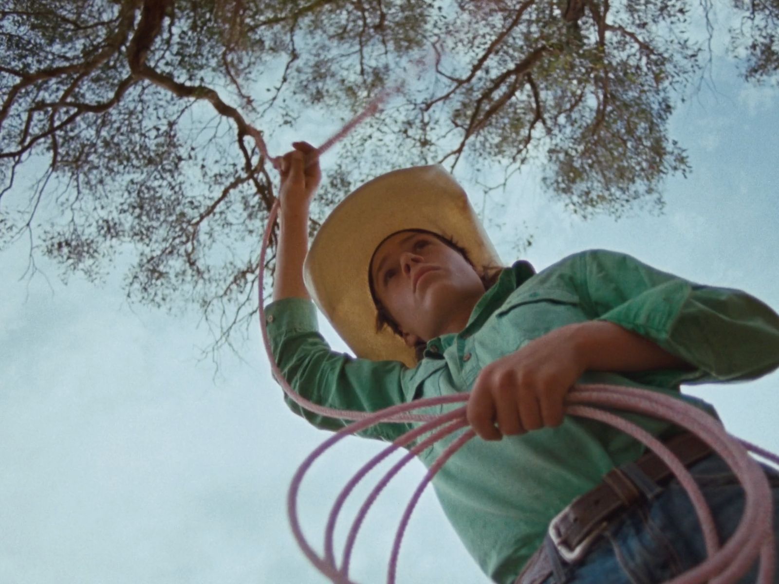 a man in a cowboy hat holding a rope