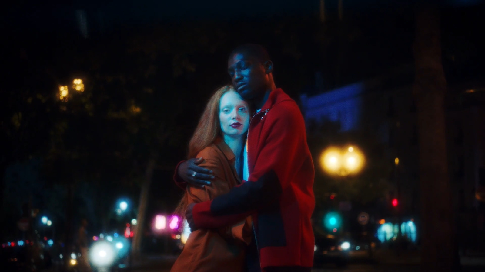 a man and a woman standing in the street at night