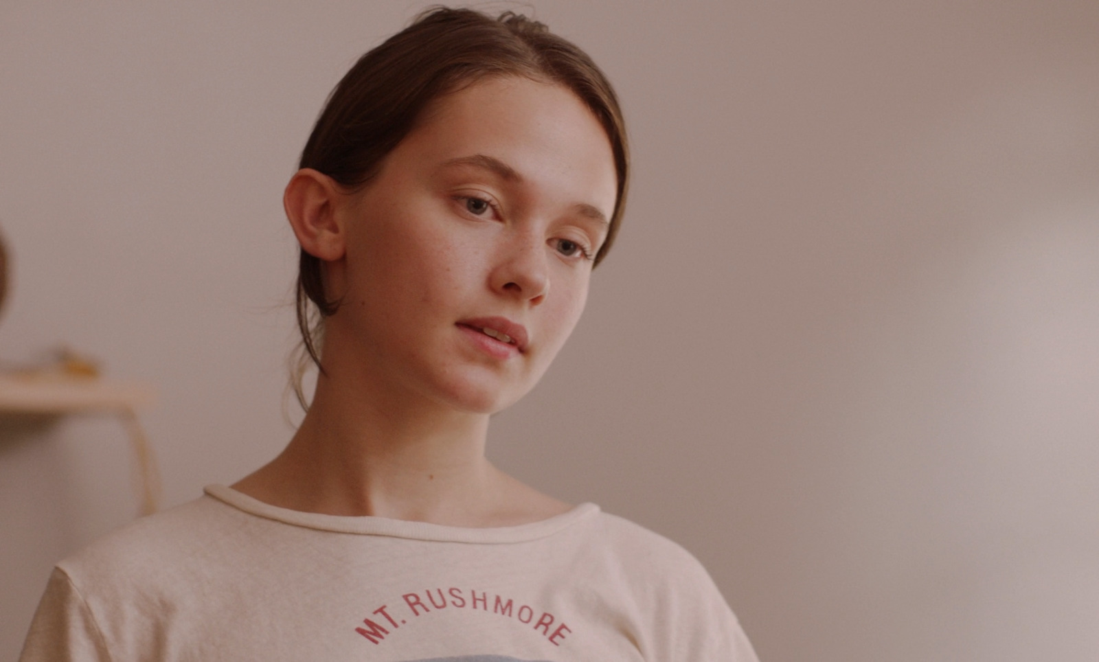 a woman in a t - shirt is staring at the camera