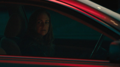 a woman sitting in a car at night