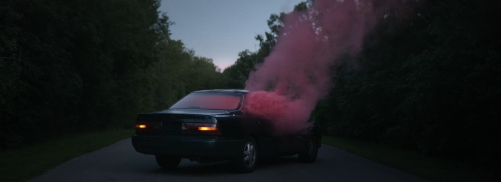 a car with pink smoke coming out of it