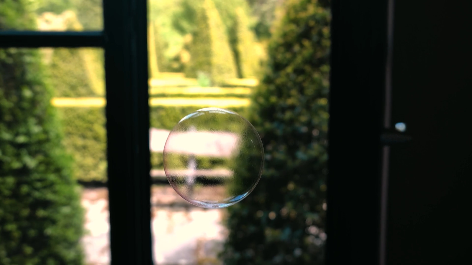 a soap bubble floating in front of a window