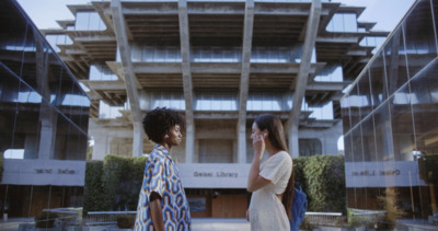 a couple of women standing next to each other in front of a building