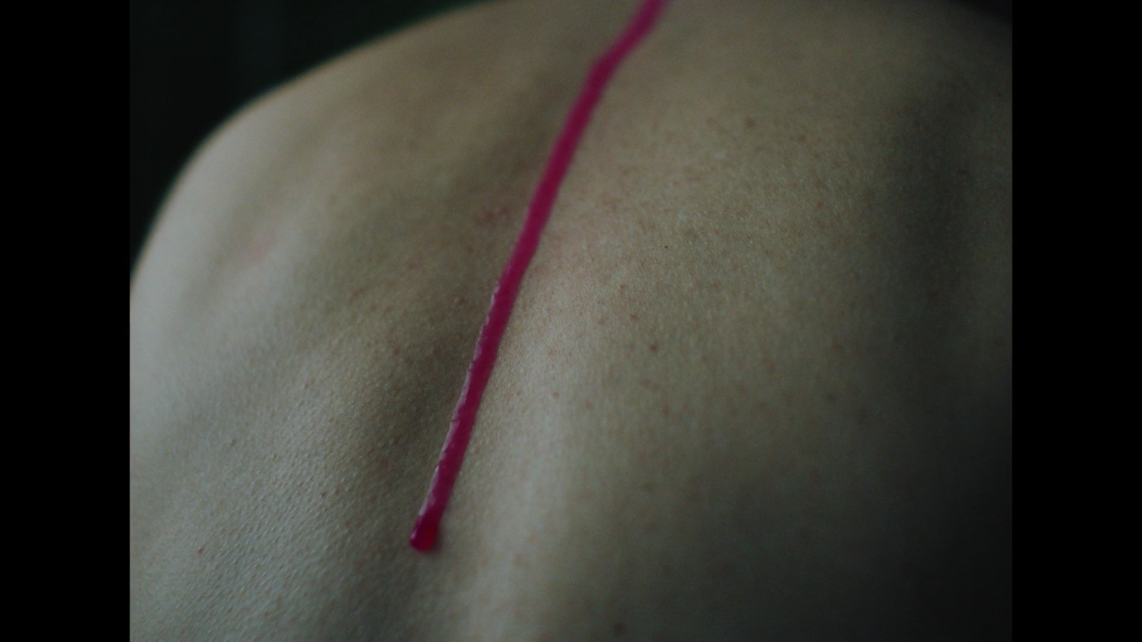 a close up of a person's back with a red thread on it